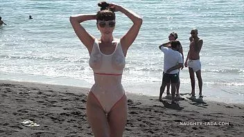 Play On the beach with her wet and transparent suit